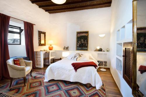 a bedroom with a bed and a chair and a table at La Guajira in Güime