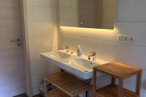 a bathroom with a sink and a mirror and a stool at Ferienhaus Vossberg in Grabow