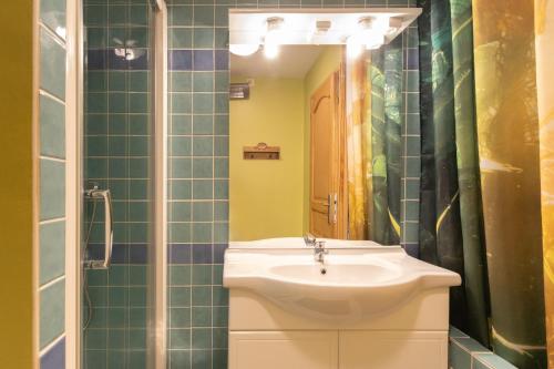 a bathroom with a sink and a mirror at Appartement N°2 - Piscine Partagée in Lagorce