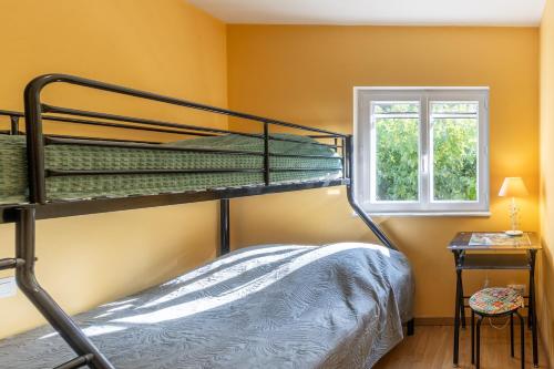 a bedroom with two bunk beds and a window at Appartement N°2 - Piscine Partagée in Lagorce