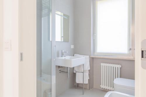 a white bathroom with a sink and a shower at Baseventuno 3 bilocale piano terra in Sirmione