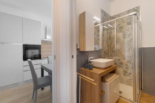 a bathroom with a sink and a kitchen with a table at Casa A Prima Vista Varazze in Varazze