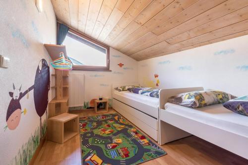 two beds in a small room with wooden ceilings at Moserhof Ferienwohnung Schartblick in Sarntal