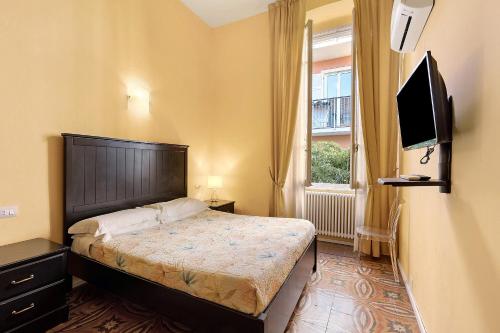 a bedroom with a bed and a flat screen tv at Botafogo in Chiavari