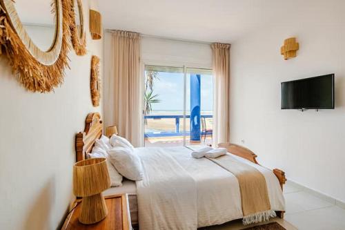 a bedroom with a bed with a view of the ocean at Villa with pool and beach access in Ben Slimane