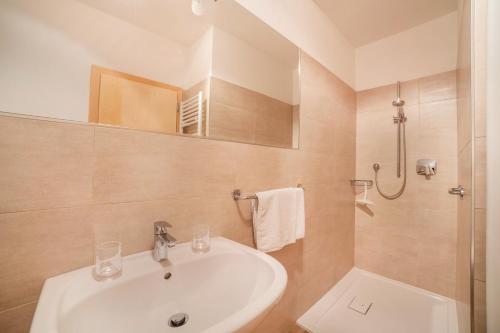 a white bathroom with a sink and a shower at Haus Hohenrain Ferienwohnung 3 in Schenna