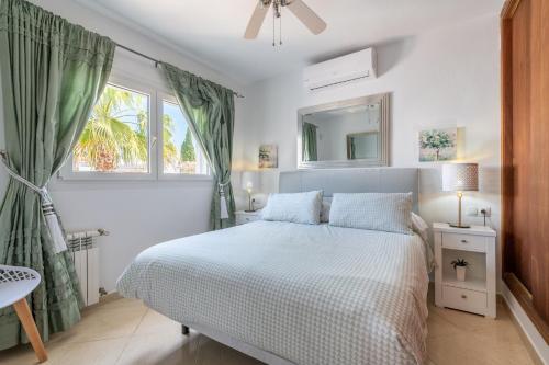 a white bedroom with a bed and a window at Villa Luca in Cala d´Or