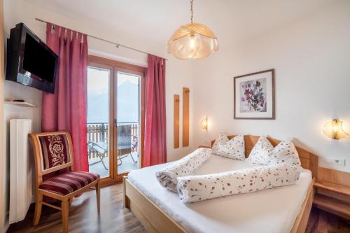 a bedroom with a bed and a large window at Haus Hohenrain Ferienwohnung 3 in Schenna