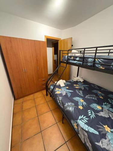 a bedroom with two bunk beds and a tiled floor at Apartament Garrota in Olp