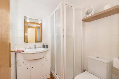a white bathroom with a sink and a toilet at Apartament Garrota in Olp