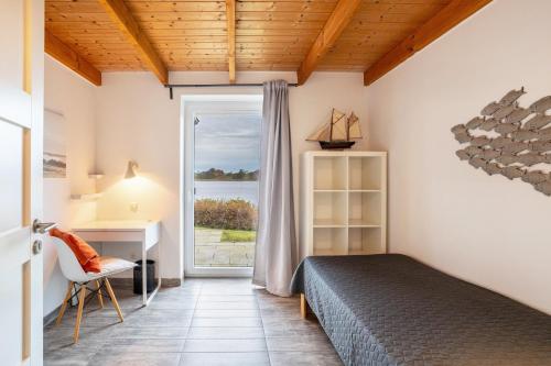a bedroom with a bed and a desk and a window at Schwanenuferhaus in Kosel