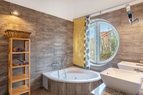 a bathroom with a tub and a sink and a window at Schwanenuferhaus in Kosel