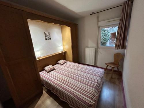 a small bedroom with a bed and a window at L'Izard Piscine, Jacuzzi, Parking in Cauterets
