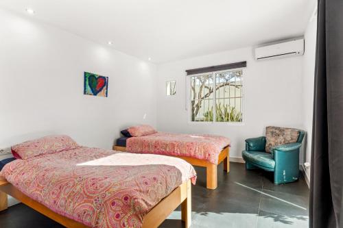 a room with two beds and a chair and a window at Casa Green in Mijas Costa