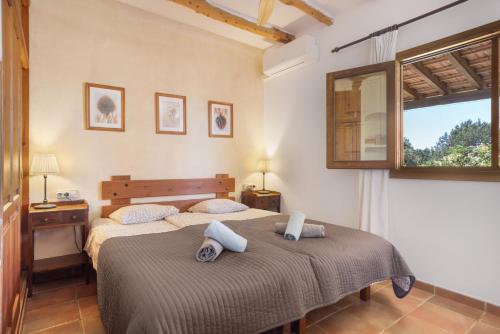 a bedroom with two beds and a window at Can Mussenya 2 in Illes Balears