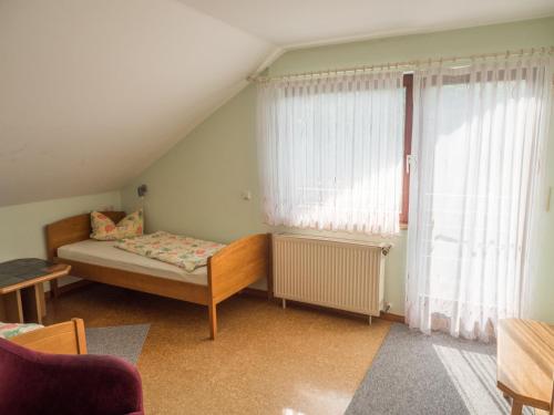 a small room with a bed and a window at Ferienhof Henn in Weikersheim
