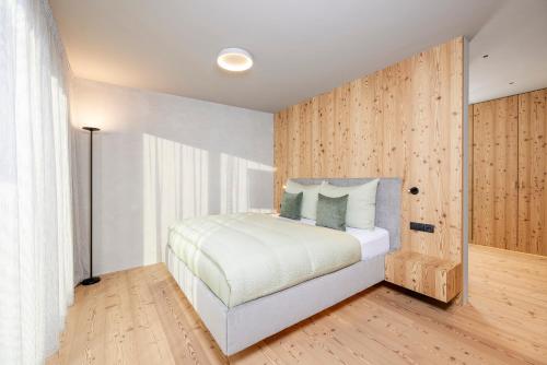 a bedroom with a bed and a wooden wall at Vronis Lodge in Hart im Zillertal