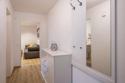 a white hallway with a mirror and a living room at Ferienwohnung Nr 5 Sonnenschein in Höchenschwand