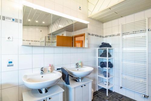 a bathroom with two sinks and a mirror at Hügelblick Oase in Kraichtal