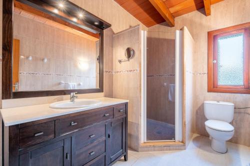 a bathroom with a toilet and a sink and a shower at Can Jaume Des Carritxó in Felanitx