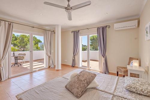 a large bedroom with a bed and a balcony at Villa Es Ratolí in Cacla D'or