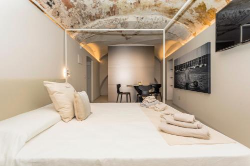 a bedroom with a large white bed with exposed ceilings at Spazio Pardo in Catania