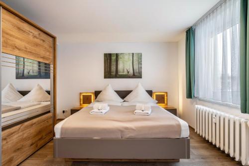 a bedroom with a large bed with two chairs on it at Pension Clara in Klipphausen