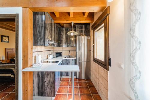 a kitchen with a sink and a refrigerator at La Dehesa de Santa Ursula in Espeja de San Marcelino