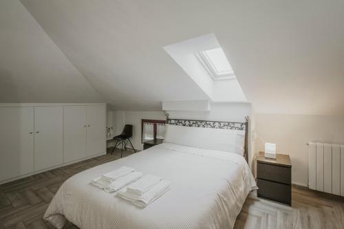 a bedroom with a white bed with towels on it at Torres 1 in Quintana de Valdivielso