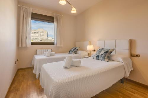 two beds in a room with a window and a couch at Central, Spacious Parking in Granada