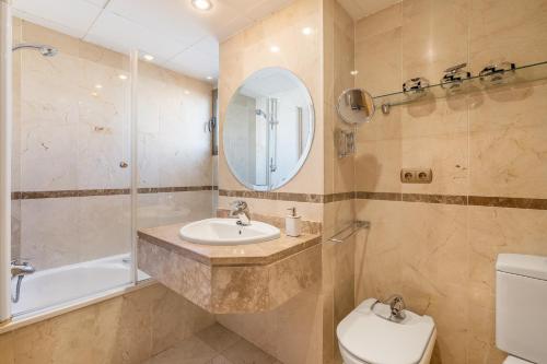 a bathroom with a sink and a toilet and a mirror at Central, Spacious Parking in Granada
