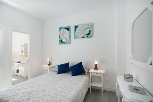 a white bedroom with a bed and a mirror at El Rincón de Mónica in Agaete