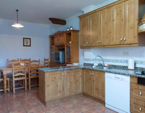 a kitchen with wooden cabinets and a dining room at Casa Rural Vielba in Barruelo de Santullán