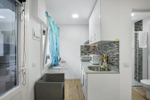 a small white kitchen with a sink and a toilet at Casa Paula - 13 in Arinaga