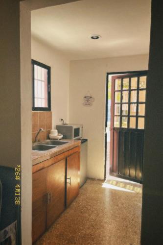 a kitchen with a sink and a microwave at Casa Rouge Alojamiento Cerca de Uman in Mérida