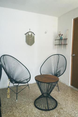 two chairs and a table in a room at Casa Rouge Alojamiento Cerca de Uman in Mérida