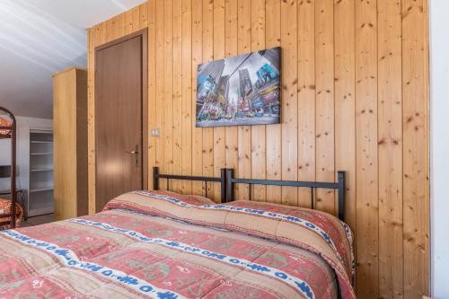 a bedroom with a bed and a wooden wall at Casa Vacanza Zambotti in Vermiglio