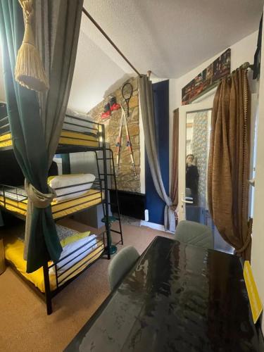 a room with bunk beds and a table at Maison Donasete voyageurs in Vieille-Brioude