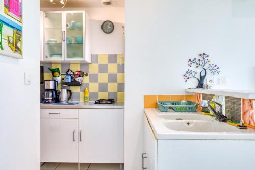 a kitchen with white cabinets and a sink at Maisonnette Lattes in Lattes