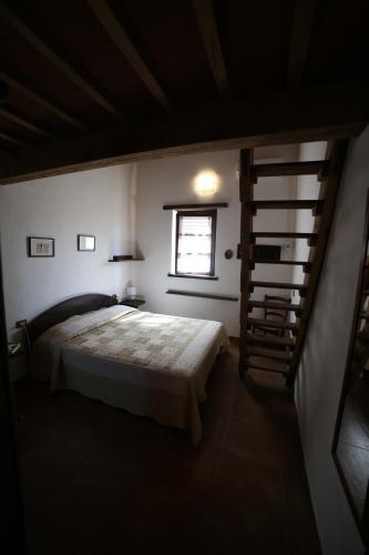 a bedroom with a bed and a spiral staircase at Il Vignone - Castagneto Carducci in Castagneto Carducci