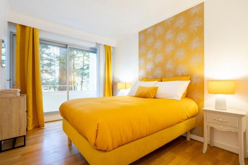a bedroom with a yellow bed and a window at Ty Corniche - 50m de la plage in Bénodet