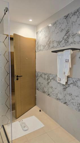 a bathroom with a shower with a glass door at Eza Hotel in Kigali