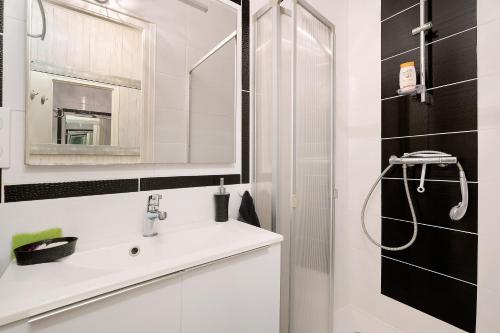 a white bathroom with a sink and a shower at Chambre Grany - Chambre in Aucaleuc