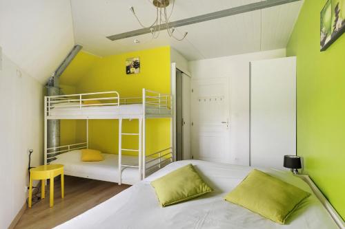 a bedroom with a bunk bed and a yellow wall at L'aérostier Gîte - 5 Pers in Saint-Georges-sur-Cher