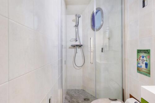 a white bathroom with a shower and a toilet at L'aérostier Gîte - 5 Pers in Saint-Georges-sur-Cher