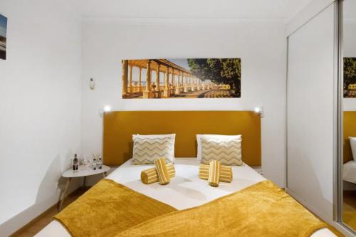 a bedroom with a bed with a yellow headboard at Douro Garden House and Pool in Vila Nova de Gaia