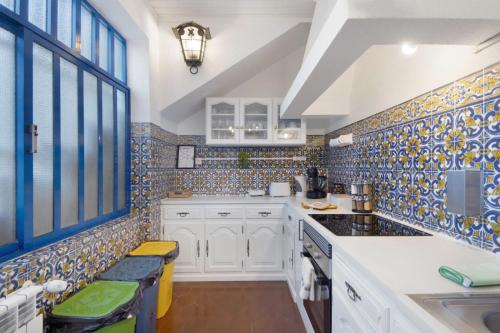 a kitchen with blue and white tiles on the wall at Douro Garden House and Pool in Vila Nova de Gaia