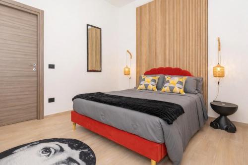 a bedroom with a large bed with a red and gray comforter at MSuite Etna Sicily in Macchia