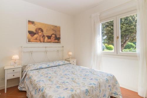 a white bedroom with a bed and two windows at La Terrazza sul Mare in Liscia di Vacca