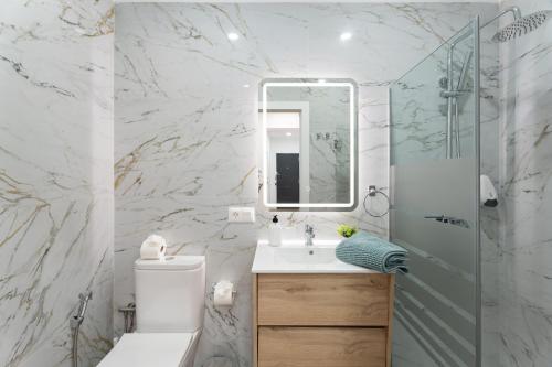 a bathroom with a toilet and a sink and a mirror at Casa Llano del Rey in Arona